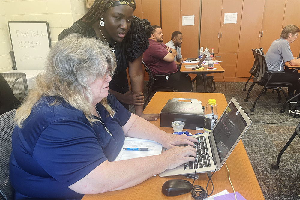 UF engineering student Ta’Neil Malcolm provides instruction to Lorraine Grice.